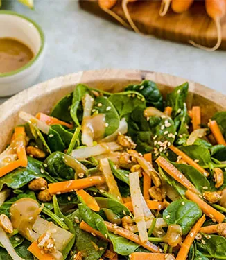 Insalata di spinaci con verdure croccanti e salsa di sesamo e arachidi